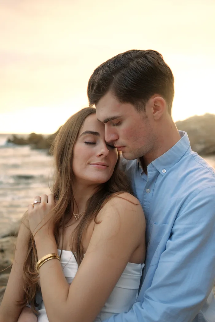 Couple embracing at sunset on the beach — engagement session by Hunter Cannon